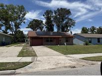 Charming single-story brick home with solar panels, a one-car garage and a well-maintained lawn at 902 Marshall St, Clearwater, FL 33755