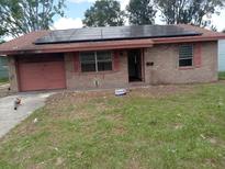 Charming single-story brick home featuring solar panels, a garage, and an inviting entrance at 902 Marshall St, Clearwater, FL 33755