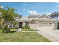 Charming single-story home featuring a two-car garage, landscaped lawn, and inviting curb appeal at 10435 Deerberry Dr, Land O Lakes, FL 34638