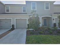 Inviting townhome showcasing a manicured lawn, gray exterior, and a convenient attached garage at 10573 Oakside Dr, Palmetto, FL 34221
