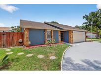 Charming home featuring stone accents, a well-maintained lawn, and stepping stones leading to the entrance at 11320 Partridge Dr, Tampa, FL 33625