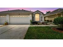 Charming single-Gathering home featuring a two-car garage and a beautifully landscaped front yard at 19409 Weymouth Dr, Land O Lakes, FL 34638