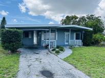 Charming single-story home with a covered carport and a well-maintained front yard at 2469 Trade Winds Dr, Dunedin, FL 34698