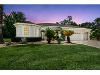 Charming single-story home featuring a well-manicured lawn, tasteful landscaping, and a two-car garage at 32015 Summerglade Dr, Wesley Chapel, FL 33545