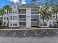 Three-story condo building with palm trees and ample parking at 3305 Haviland Ct # 101, Palm Harbor, FL 34684