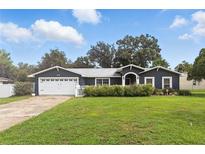 Charming single-story home featuring a well-manicured lawn, attached garage, and a welcoming entrance at 37331 Hickory Hill Ln, Dade City, FL 33525