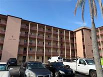 Multi-story condo building featuring balconies, covered parking, and well-maintained exterior against a bright, blue sky at 4137 Lake Bayshore Dr # C505, Bradenton, FL 34205