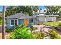 Charming home with a bright orange front door and lush landscaping at 5005 Tangerine S Ave, Gulfport, FL 33707