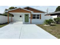 Charming renovated home featuring a carport, freshly painted exterior, and a bright green front door at 5151 7Th N Ave, St Petersburg, FL 33710