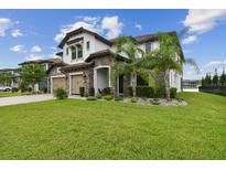 Beautiful two-story home with a well-manicured lawn, three-car garage, and tasteful stone accents at 6129 Marsh Trail Dr, Odessa, FL 33556