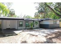 Charming single-story home with gray and white trim, covered front porch, and well-manicured lawn at 9218 Memorial Hwy, Tampa, FL 33615