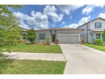 Charming single-story home featuring a well-manicured lawn and a welcoming two-car garage at 10308 Malvasia Ave, Riverview, FL 33578
