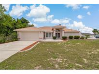 Charming single-story home featuring a tile roof, well-manicured lawn and mature landscaping at 11411 Terrell, Spring Hill, FL 34606