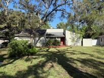 Single-Gathering home with mature trees, lush green lawn, and charming curb appeal at 12206 N 53Rd St, Temple Terrace, FL 33617