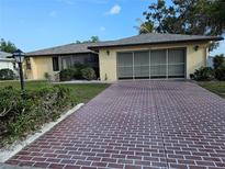 Charming single-story home with a well-maintained lawn, brick driveway, and attached garage at 1510 Flamingo Ln, Sun City Center, FL 33573