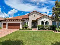 Charming home with a red tile roof, lush green lawn, and manicured landscaping creates inviting curb appeal at 3236 Barbour Trl, Odessa, FL 33556