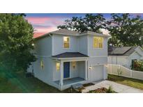 Charming two-story home with a light blue exterior, covered porch, and well-maintained landscaping at 4312 E Shadowlawn Ave, Tampa, FL 33610