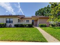 Charming single-story home with a well-maintained lawn, inviting walkway, and manicured landscaping at 50 Ingrid Pl # 50, Oldsmar, FL 34677