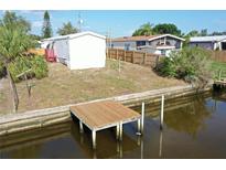 Exterior view of the waterfront property with a private wooden dock extending into the canal at 5824 Coventry Dr, Tampa, FL 33615