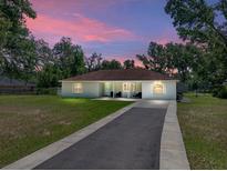 Charming single-story home with a well-manicured lawn, a long driveway, and covered front porch at 5926 Frontier Dr, Zephyrhills, FL 33540