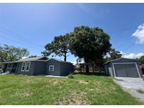 Charming home featuring a lush backyard, detached garage, and inviting pergola for outdoor gatherings at 6426 S Himes Ave, Tampa, FL 33611