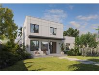 Modern two-story home featuring a sleek design, a well-manicured lawn and lush tropical landscaping at 805 Paris S Ave, St Petersburg, FL 33701