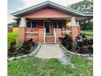 Charming home featuring a covered porch, landscaped front yard, and a welcoming entrance at 9907 Maggie St, Gibsonton, FL 33534