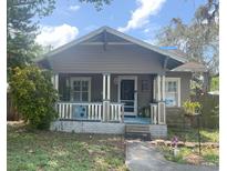Charming bungalow with a covered front porch and mature landscaping at 1105 E Ellicott St, Tampa, FL 33603