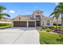 Charming two-story home with a three-car garage, a tile roof, and lush tropical landscaping at 1178 Fraser Pine Blvd, Sarasota, FL 34240
