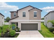 Charming two-story home with a two-car garage, well-manicured lawn, and inviting front entrance at 14460 English Lavender Dr, Wimauma, FL 33598