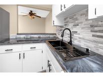 Modern kitchen with white cabinets, black fixtures, and backsplash at 1881 Lichen Ln # B, Clearwater, FL 33760