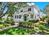 Charming two-story home featuring a green door, manicured landscaping, and brick pathway at 258 14Th Ne Ave, St Petersburg, FL 33701