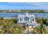 Stunning coastal home with a metal roof, multiple balconies, and scenic waterfront views at 3 Pointe Way, Placida, FL 33946