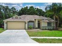 Charming single-story home with a two-car garage, mature landscaping, and a well-maintained lawn at 3405 Silver Glen Ct, Plant City, FL 33566