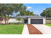 Charming single-story home with a well-manicured lawn and an attached two-car garage at 3408 W Swann Ave, Tampa, FL 33609