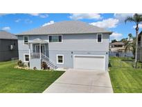 Beautiful two-story home with a well-manicured lawn and an attached two-car garage near a canal at 4123 Daisy Dr, Hernando Beach, FL 34607
