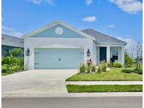 Charming single-story home featuring a two-car garage, manicured lawn, and a lovely blue-and-white color scheme at 4510 Big Woods Way, Parrish, FL 34219