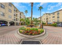 Beautiful water fountain and landscaped entrance to a luxury condominium building with palm trees at 501 Knights Run Ave # 1209, Tampa, FL 33602