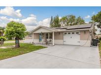 Charming single-story home featuring a well-maintained lawn, a two car garage and solar panels on the roof at 7901 Marlboro Dr, Port Richey, FL 34668