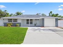 Charming single-story home featuring a well-manicured lawn and attached garage at 8030 Jasmine Blvd, Port Richey, FL 34668