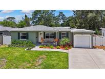 Charming single-story home featuring a well-manicured lawn and a welcoming front porch with decorative landscaping at 9000 Bay Ne St, St Petersburg, FL 33702