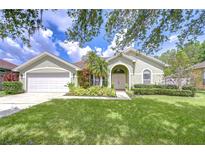 Charming single-story home with lush landscaping, well-manicured lawn and a two car garage at 9813 Woodbay Dr, Tampa, FL 33626