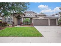 Charming single-story home with well-manicured lawn and a three-car garage and beautiful landscaping at 1342 Salmonberry St, Wesley Chapel, FL 33543