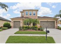 Charming two-story home featuring a three-car garage and a well-manicured lawn with mature landscaping at 1902 Marshberry Ct, New Port Richey, FL 34655