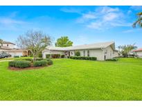 Charming single-story home boasts a lush green lawn, manicured bushes and vibrant landscaping at 1917 Iowa Ne Ave, St Petersburg, FL 33703