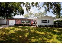 Charming single-story home with a brick facade, manicured lawn, and an attached one-car garage at 2010 6Th Sw Ave, Largo, FL 33770