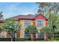 Charming exterior with colorful stucco, tile roof, and lush landscaping at 2171 Portofino Pl # 27-2725, Palm Harbor, FL 34683