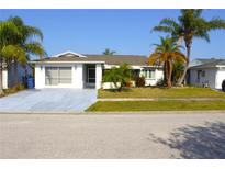 Charming single-story home with a two-car garage, lush landscaping, and inviting curb appeal at 2211 Harrison Dr, Holiday, FL 34691