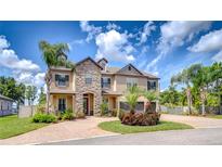 Stunning two-story home boasts lush landscaping, stone accents, and a welcoming paver driveway at 2566 Lake Manor Dr, Land O Lakes, FL 34639