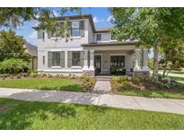 Charming two-story home showcasing a well-manicured lawn, stone accents, and a welcoming front porch at 3257 Heart Pine Ave, Odessa, FL 33556